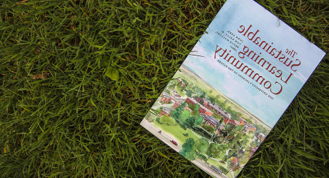 The Sustainable Learning Community book on the grass